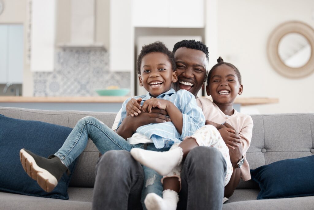 Cropped portrait of an affectionate young family of three relaxing in the living room at home