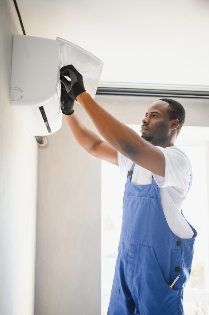 Happy Young African Male Technician Repairing Air Conditioner | Dan's HVAC