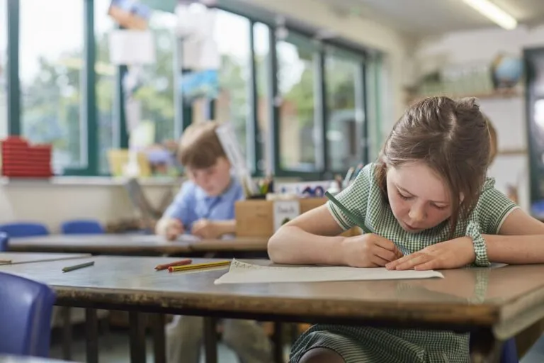 schoolgirl writing in classroom lesson in primary school | Dan's HVAC