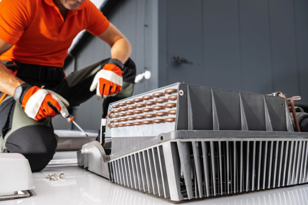 Technician Repairing Air Conditioner Unit on a Camper Van Rooftop.
